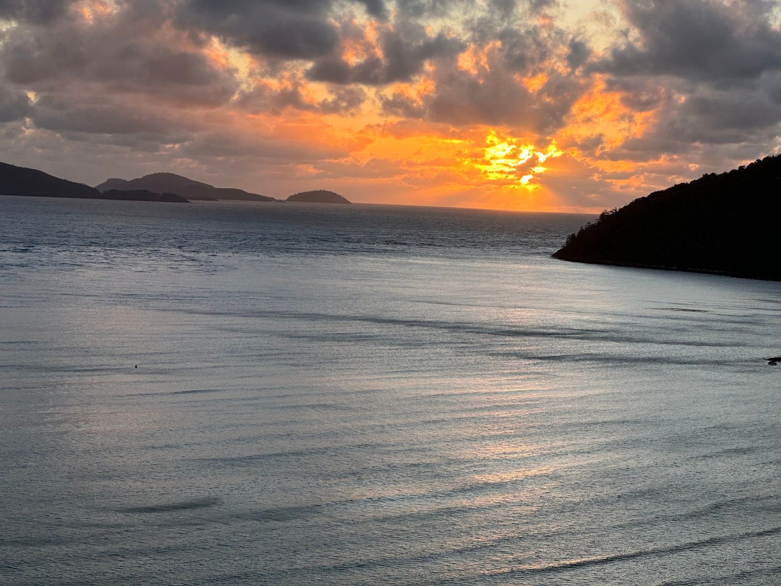 The sun rising through the clouds over the Whitsunday islands, seen from our balcony