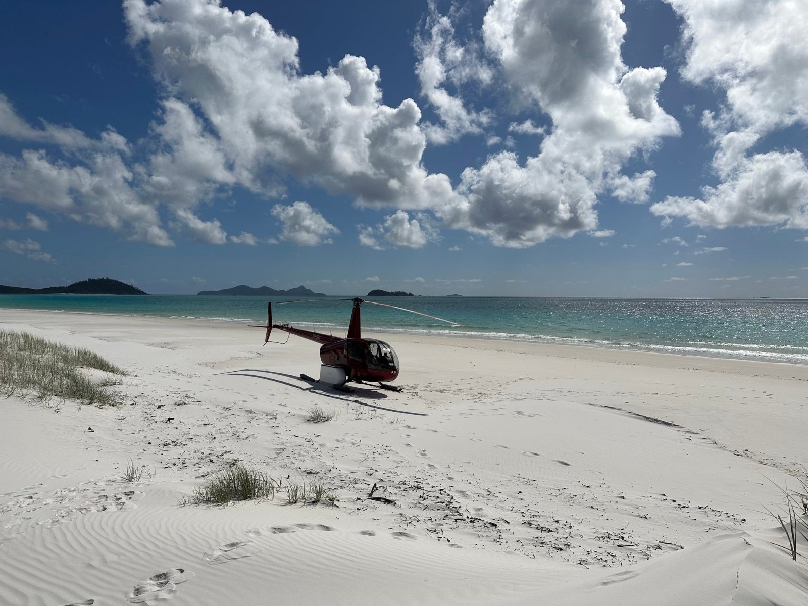 Our helicopter waiting on the white sand of Whitehaven Beach