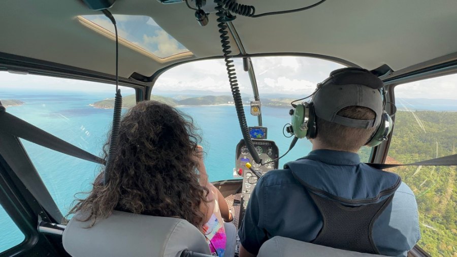 Looking past Meenu and the pilot to the sea and islands on the flight back