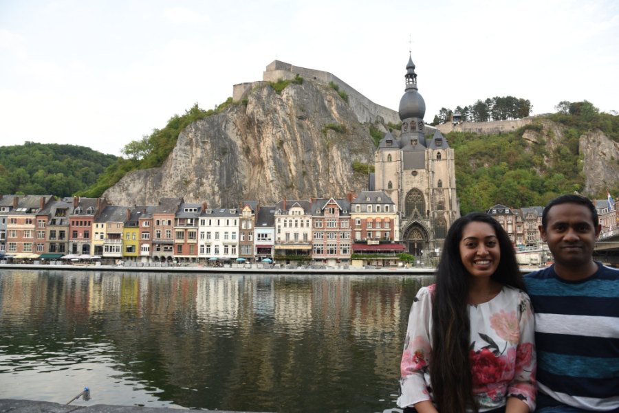 Meenu and Praddy by the Meuse, with Dinant's coloured houses, church and citadel behind