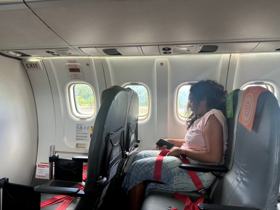 Meenu in a window seat on the Air Tahiti propeller plane