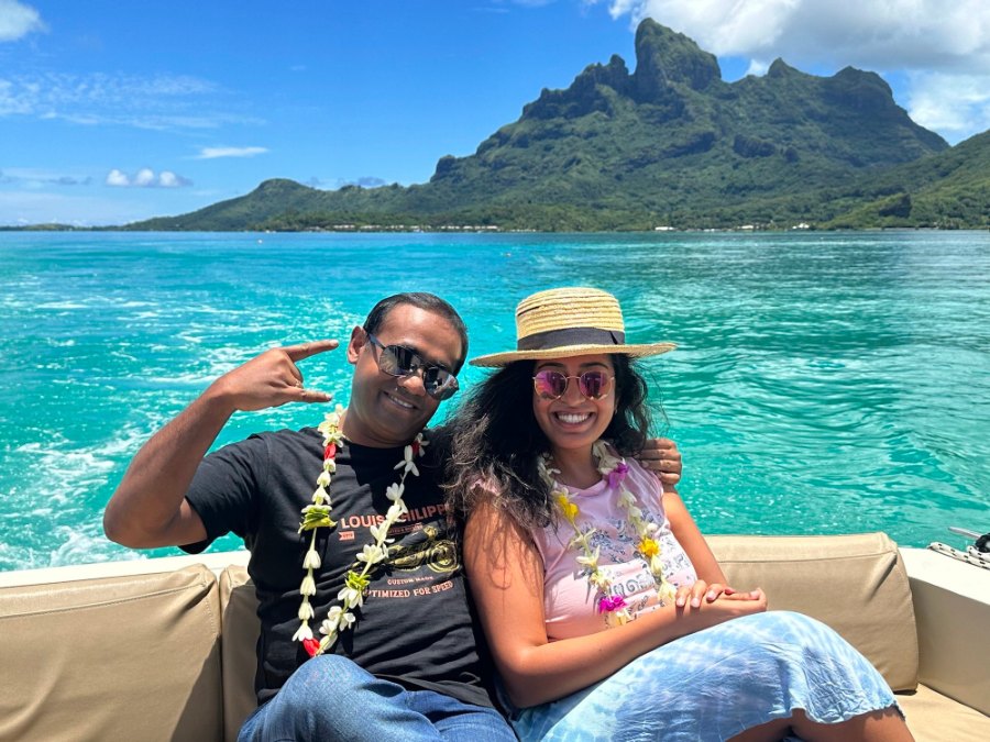 Meenu and Praddy in flower garlands on the boat across the lagoon, with Otemanu behind