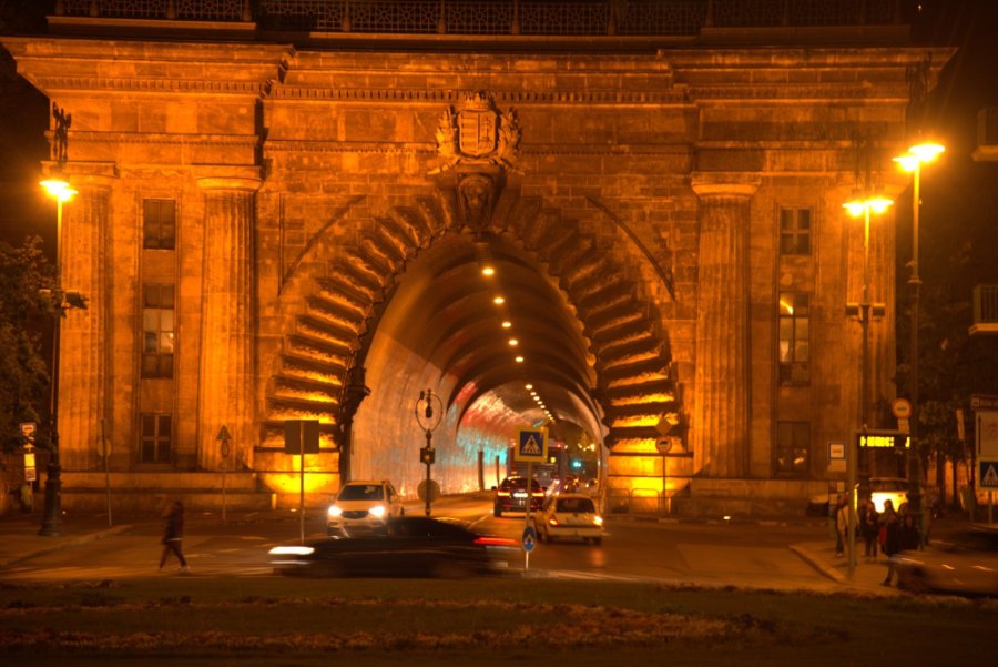 The arched entrance of the tunnel under Castle Hill, lit orange, with traffic going in