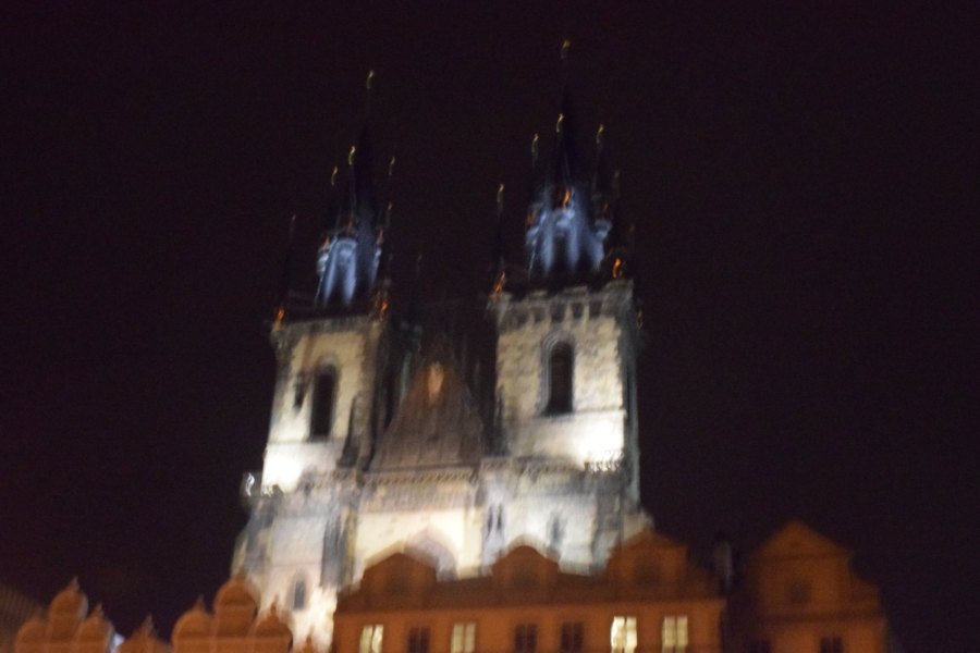 The twin spires of the Týn Church floodlit against the night sky