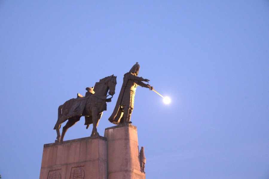 The Gediminas monument at dusk, with the moon sitting on the tip of his outstretched sword