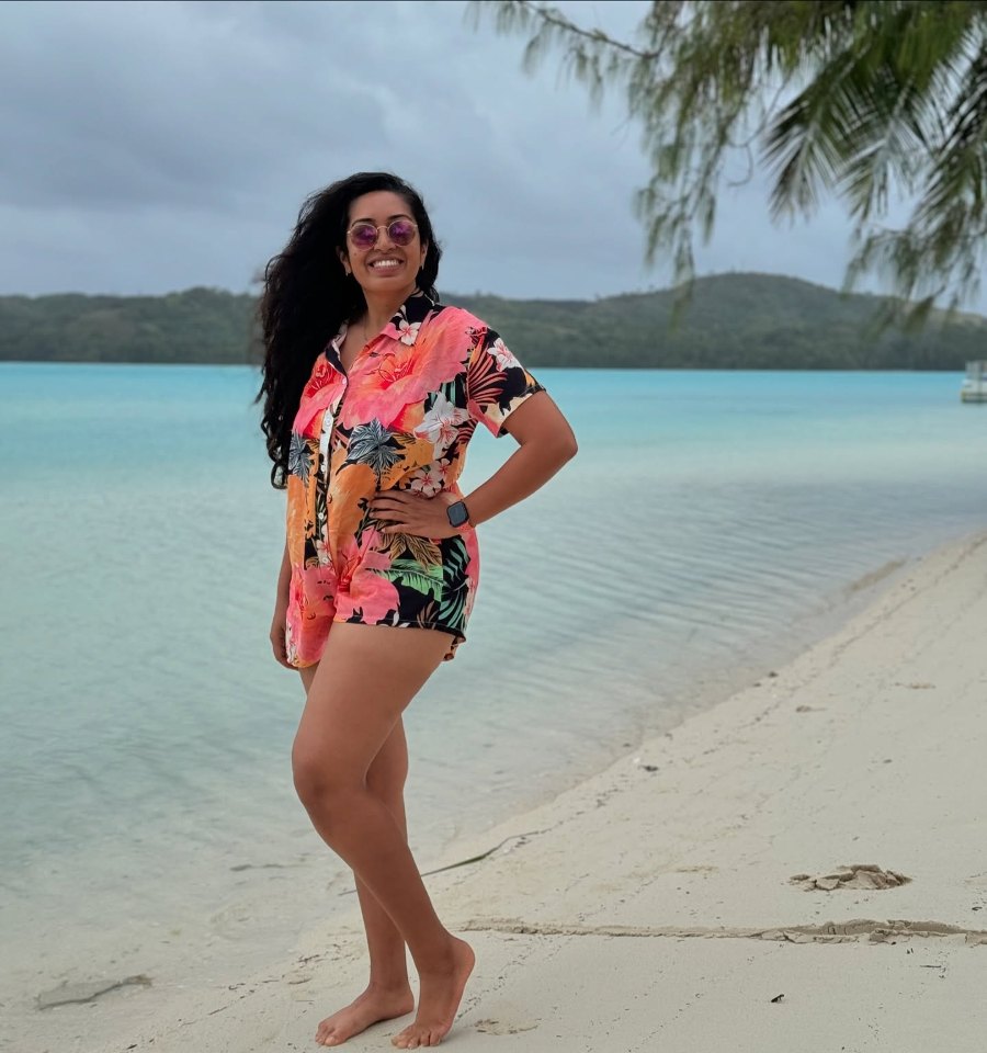 Meenu on Ootu Beach, with the shallow lagoon and green hills behind her