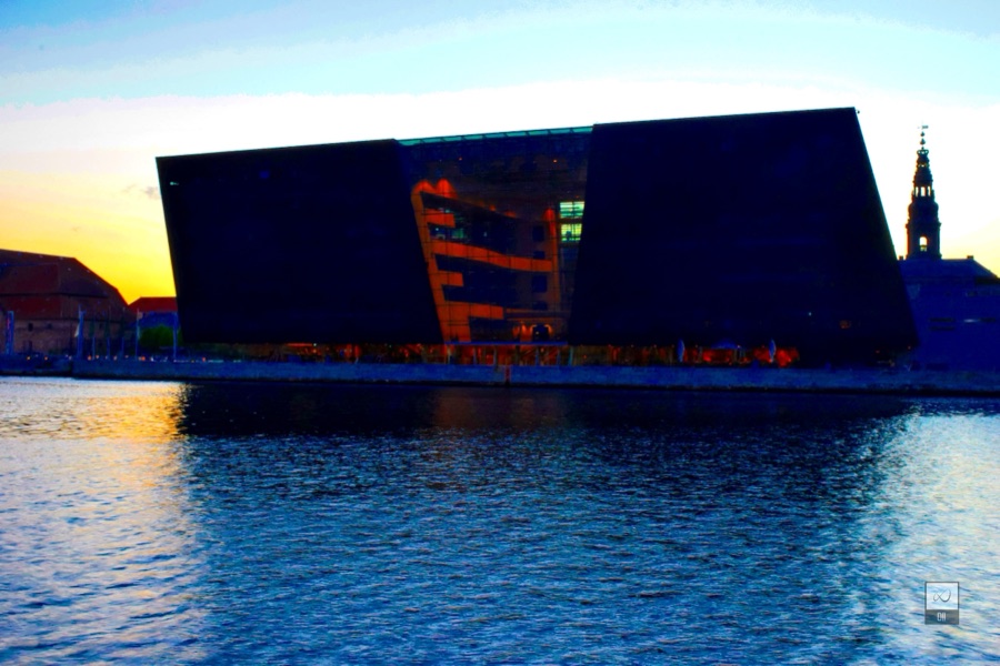 The Black Diamond's dark glass against a sunset sky, above the water