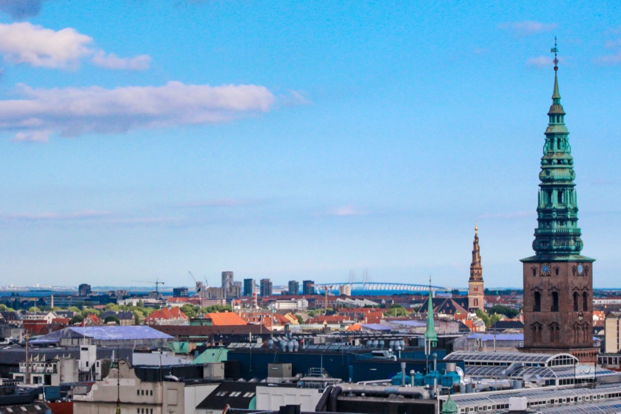 Rooftops from the Round Tower, with a green copper spire close by and the Øresund Bridge on the horizon