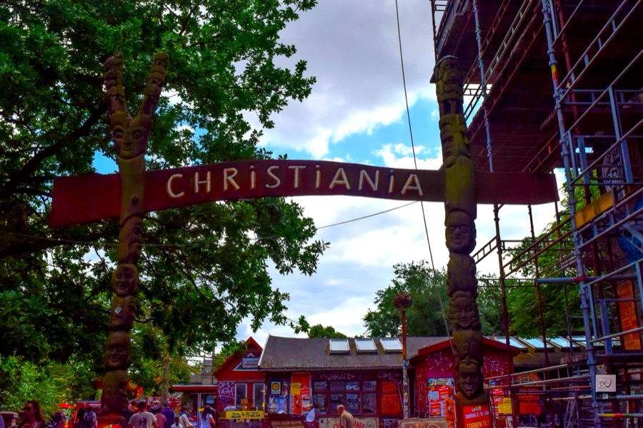 The painted Christiania sign arching over the entrance between carved wooden posts