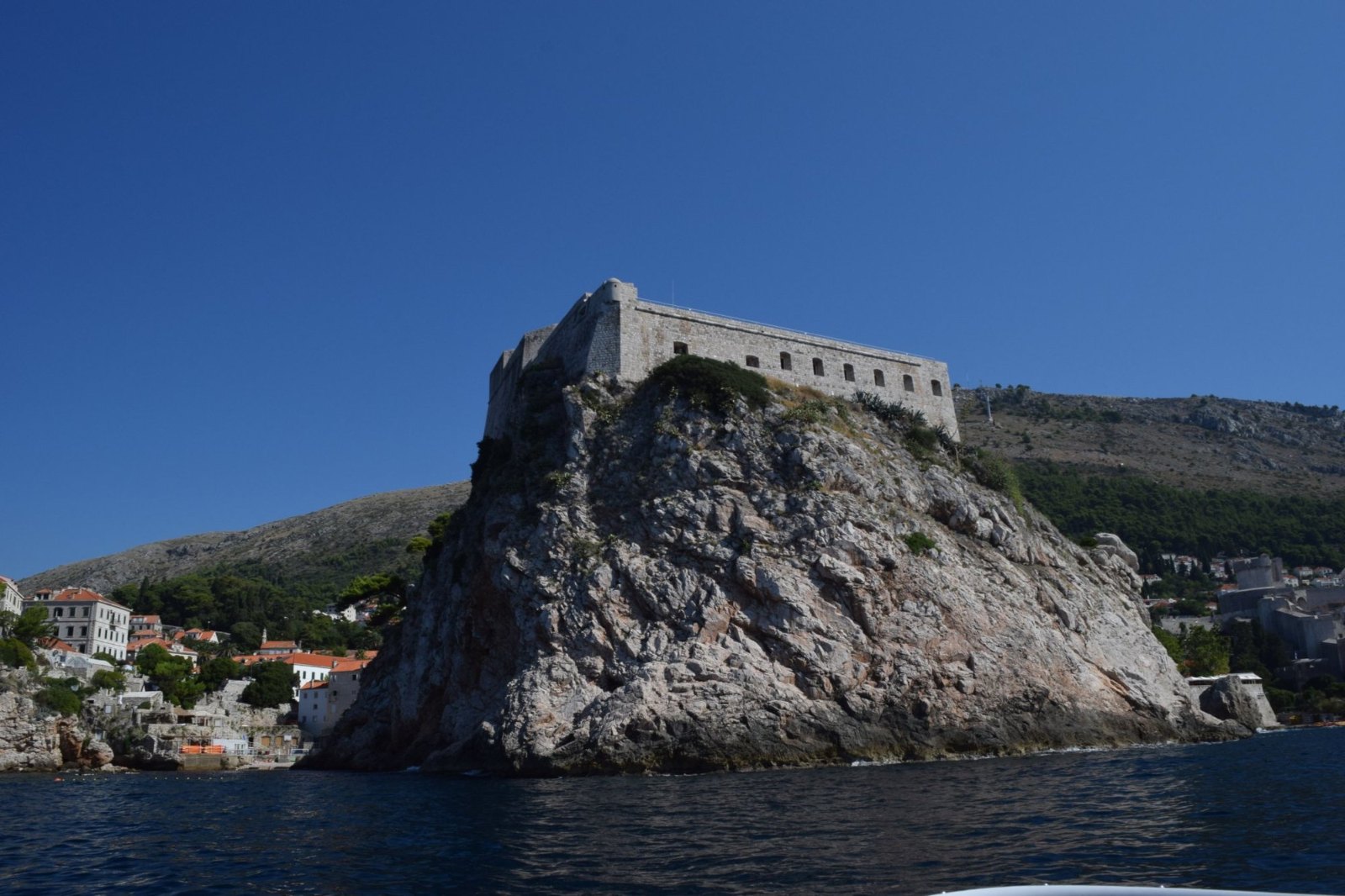 Lovrijenac fortress on top of its sheer rock above the sea, seen from the speedboat