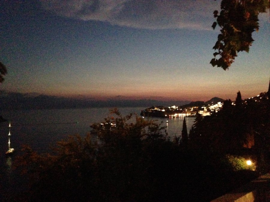 The old town's lights across the bay at dusk, seen from the terrace