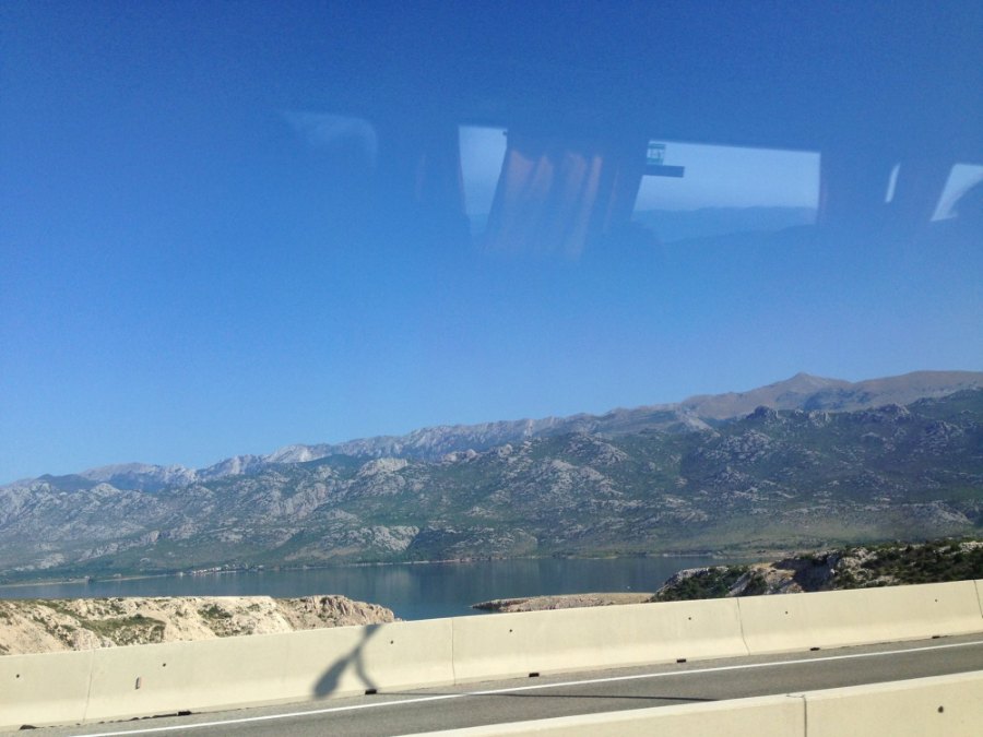 Bare grey mountains above a strip of water, through the coach window on the way north
