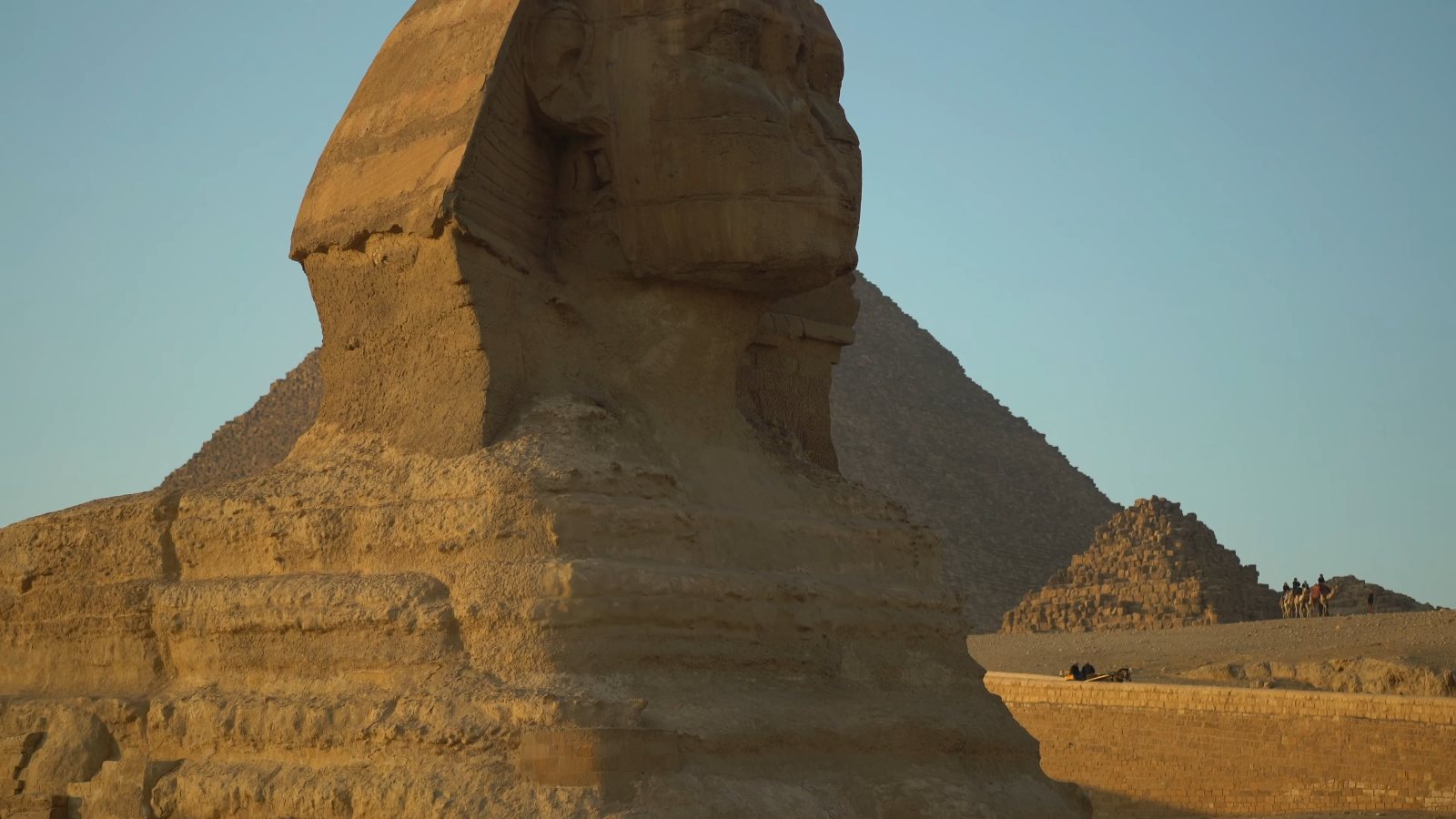 The Sphinx in warm low sun, with a pyramid rising behind it