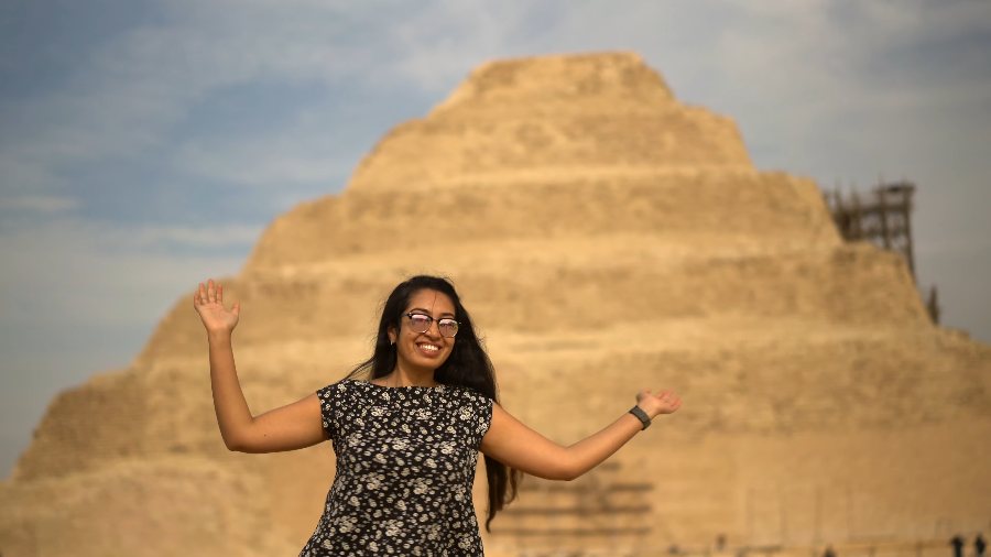 Meenu dancing with her arms out in front of the Step Pyramid at Saqqara