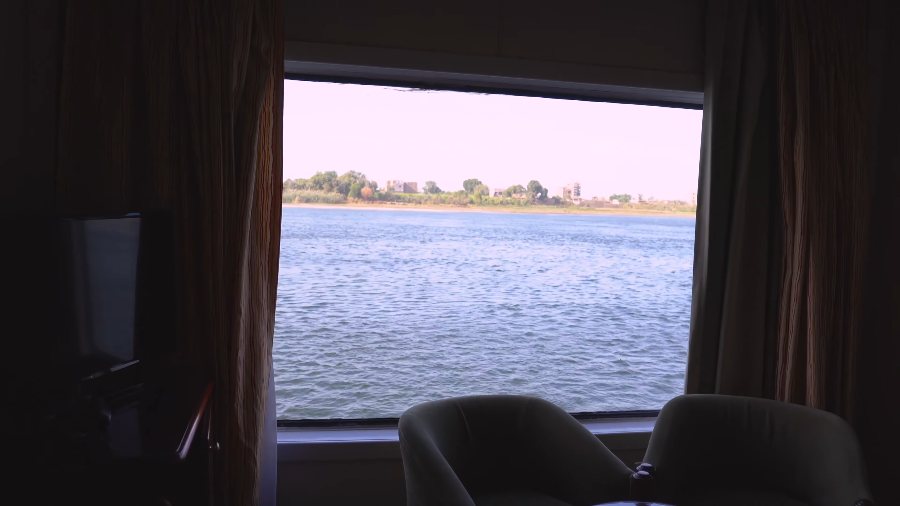 The Nile through the big window of our cabin, with two armchairs in front of it