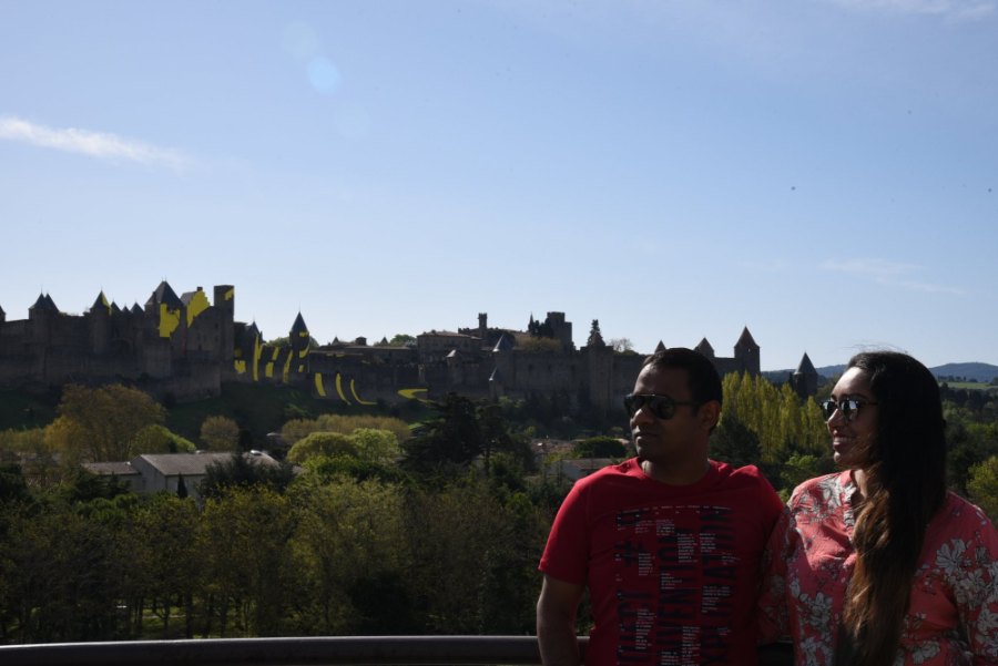 Meenu and Praddy in the morning sun, with the Cité's walls and towers on the hill behind them