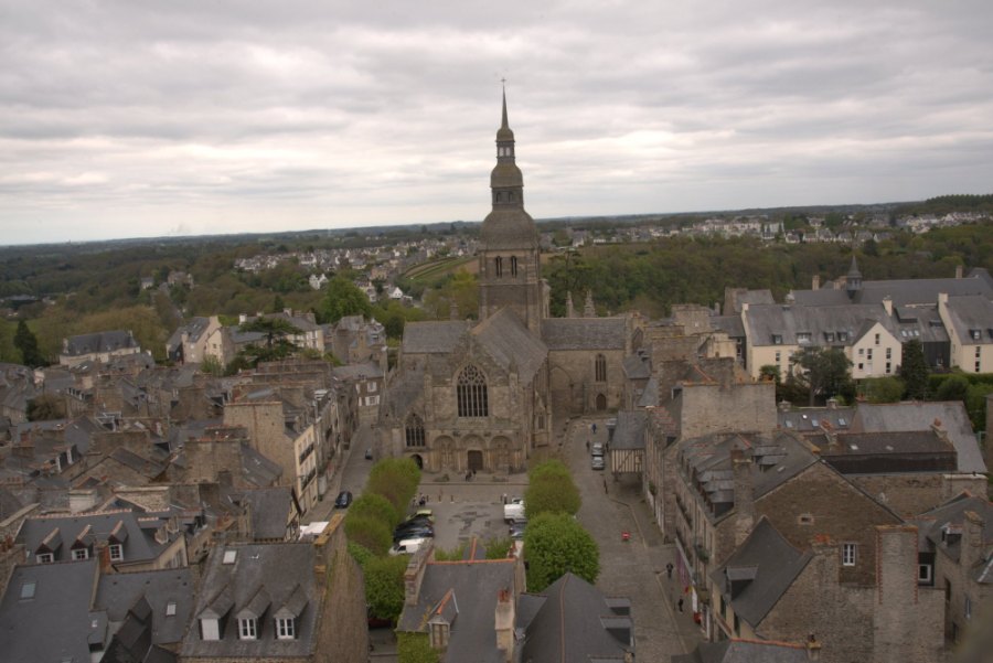 Dinan's grey slate roofs from high above, running out to a church spire and green country beyond