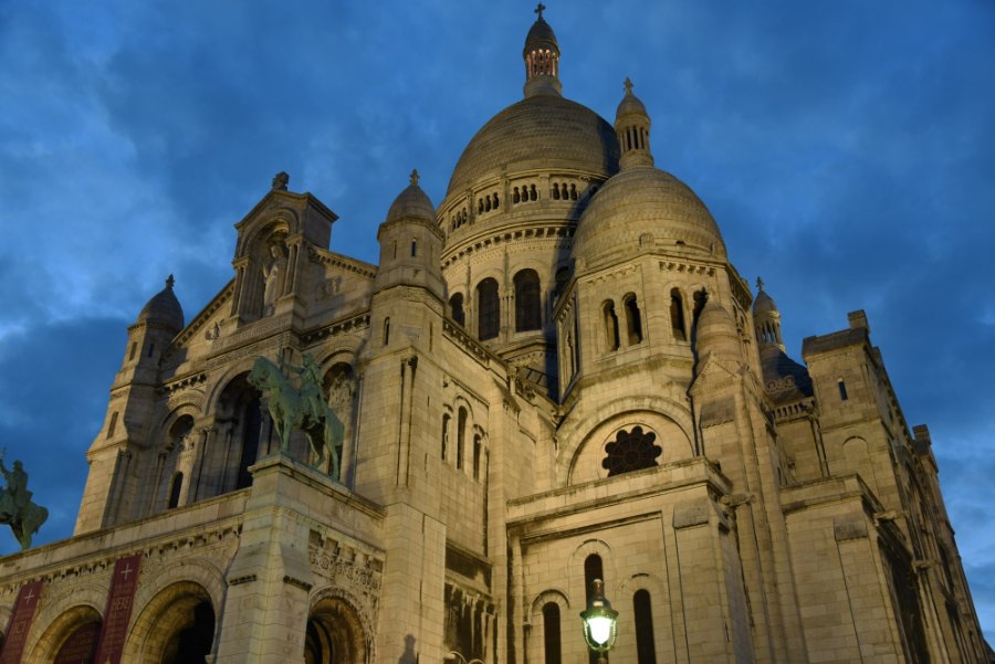 Sacré-Cœur's domes lit up against a deep blue evening sky