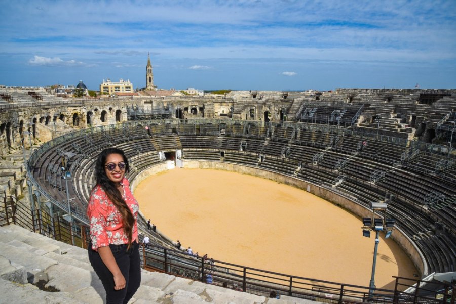 Meenu on the top tier of the amphitheatre, with the rings of stone seats and the sandy arena below