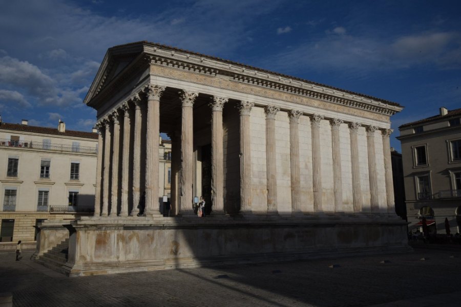 The Maison Carrée, a Roman temple fronted by tall columns, in the evening light