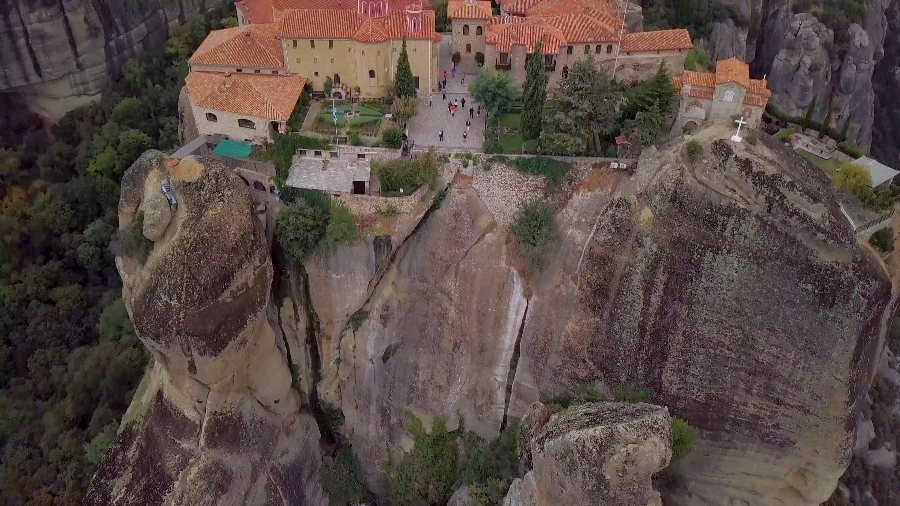 A monastery's red roofs on top of a sheer rock pillar at Meteora