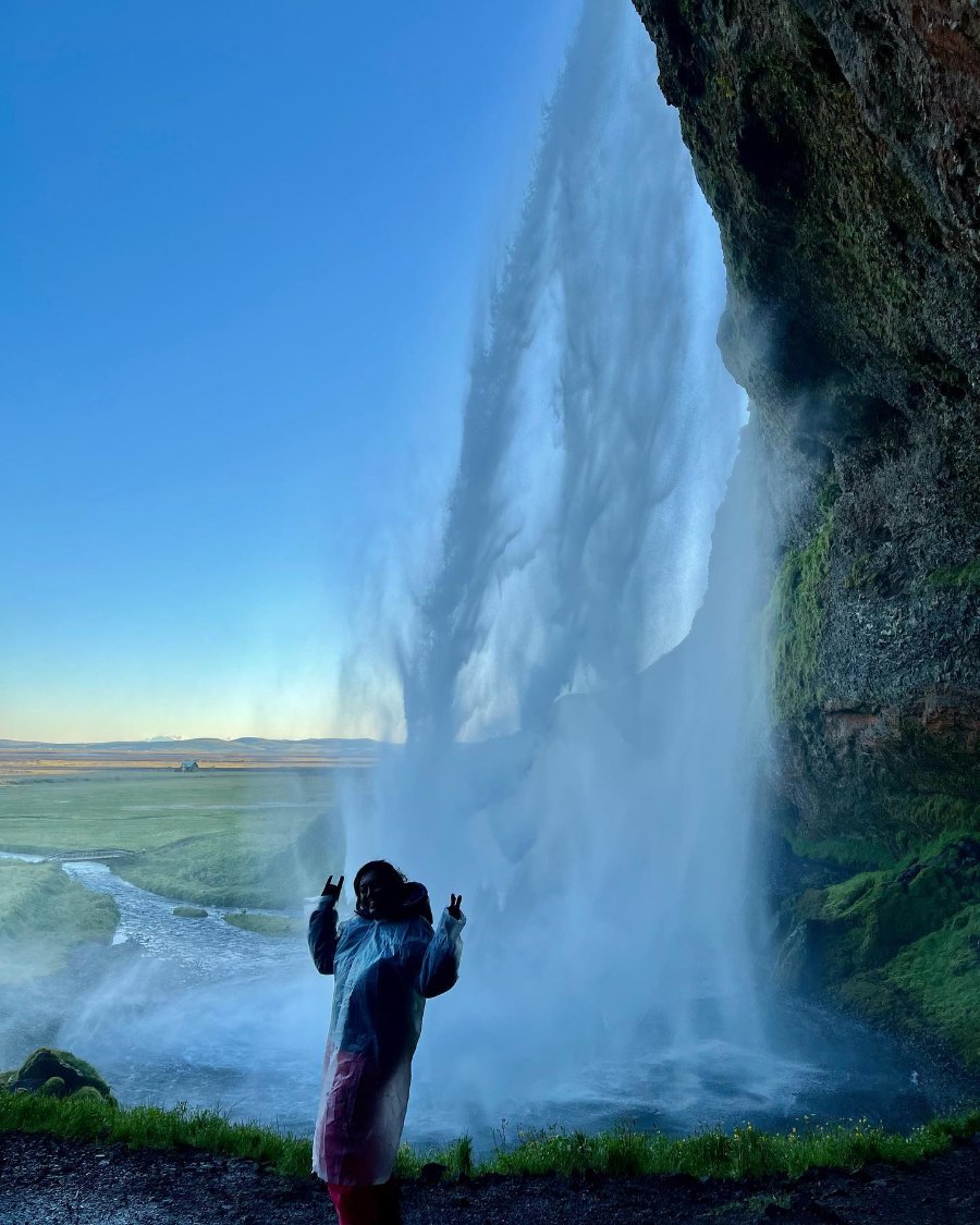 Meenu behind Seljalandsfoss, taking a photo through the curtain of falling water