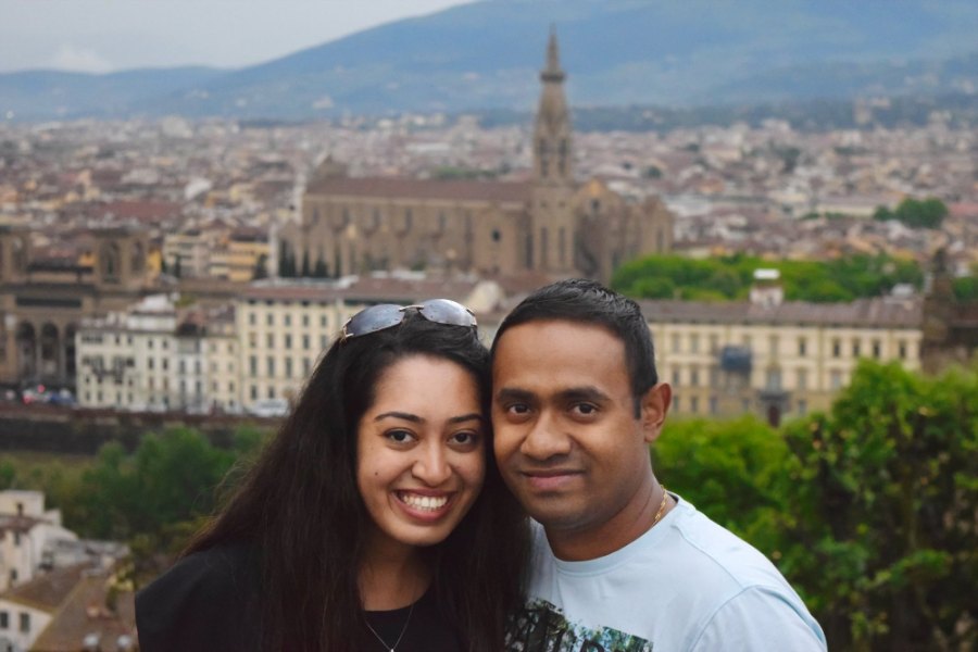 Meenu and Praddy smiling cheek to cheek above the city, with Santa Croce behind them