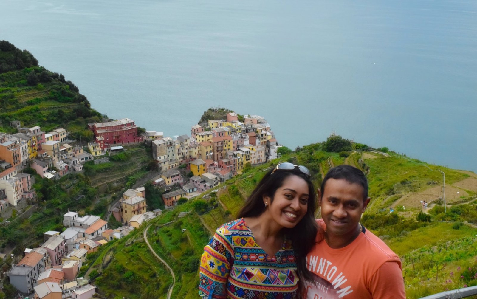 Meenu and Praddy on the vineyard slope above Manarola, its painted houses piled on the rock below