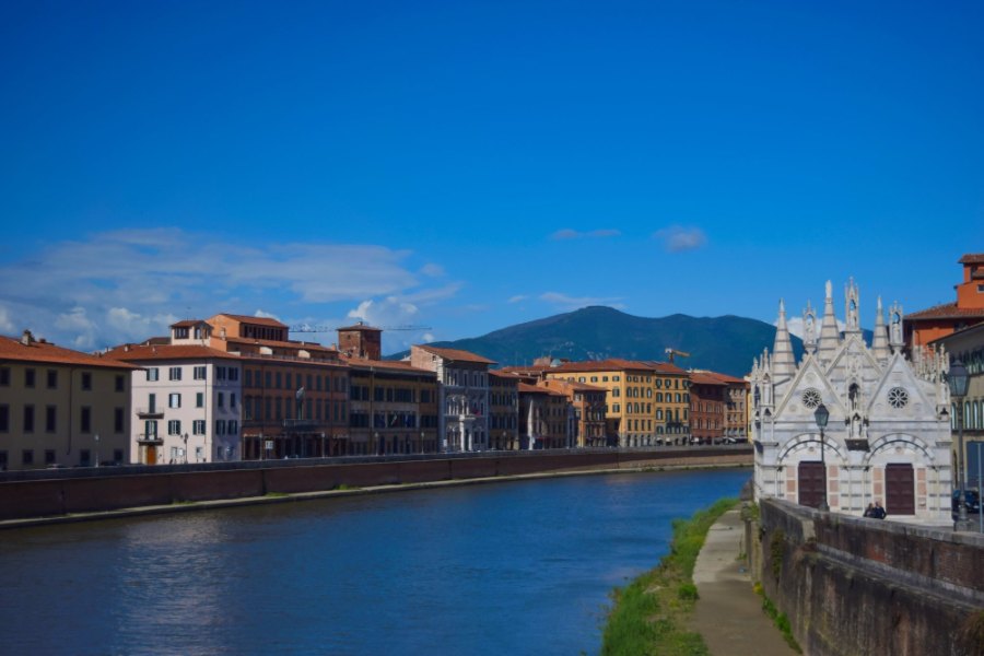 The Arno lined with yellow and orange houses, and the small white chapel of Santa Maria della Spina on the bank