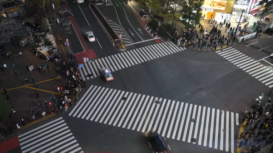 Shibuya Crossing from above, with crowds gathered on every corner
