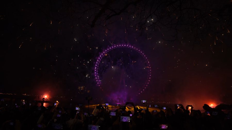 The Eye's rim glowing purple alone in the dark, with red lights by the water