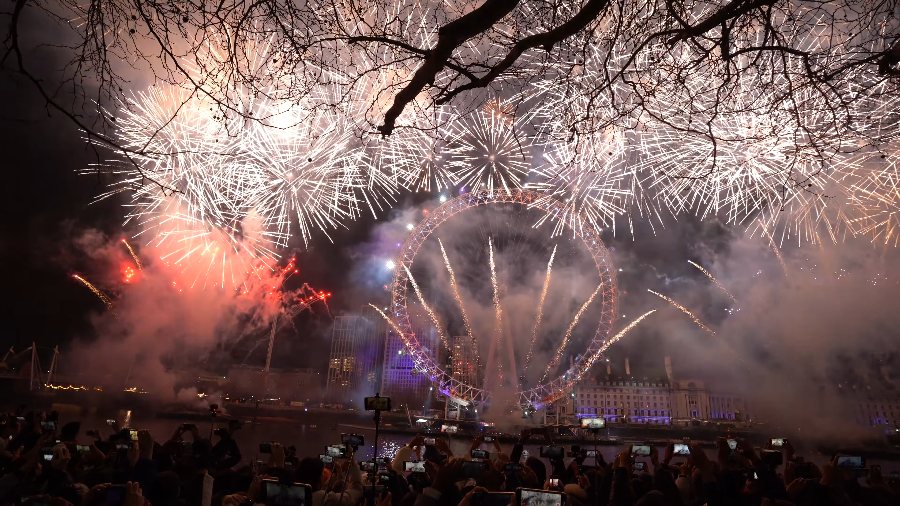 A wall of white shells filling the sky under bare branches, with red smoke beside the Eye