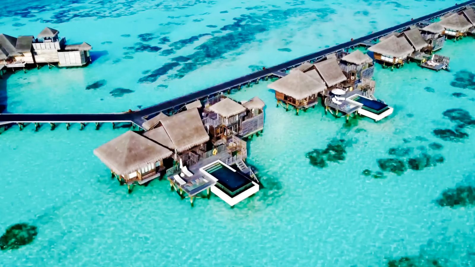 Drone view of Gili Lankanfushi's thatched overwater villas and their private pools