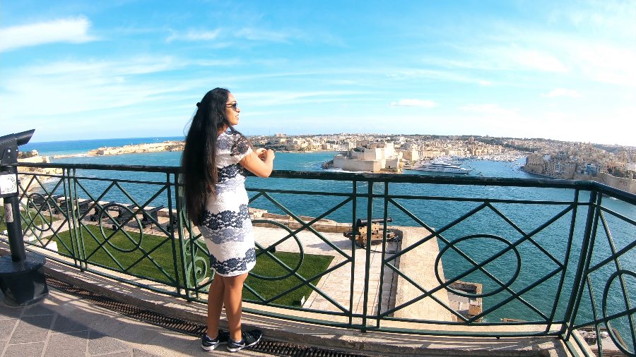 Meenu at the railings of the Upper Barrakka Gardens, looking out over the Grand Harbour