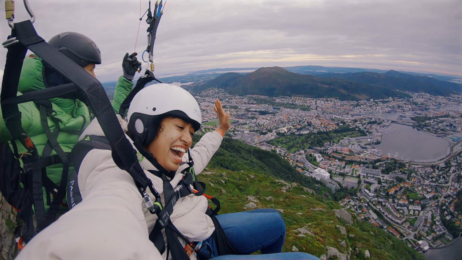 Meenu laughing on a tandem paraglider flight high above Bergen