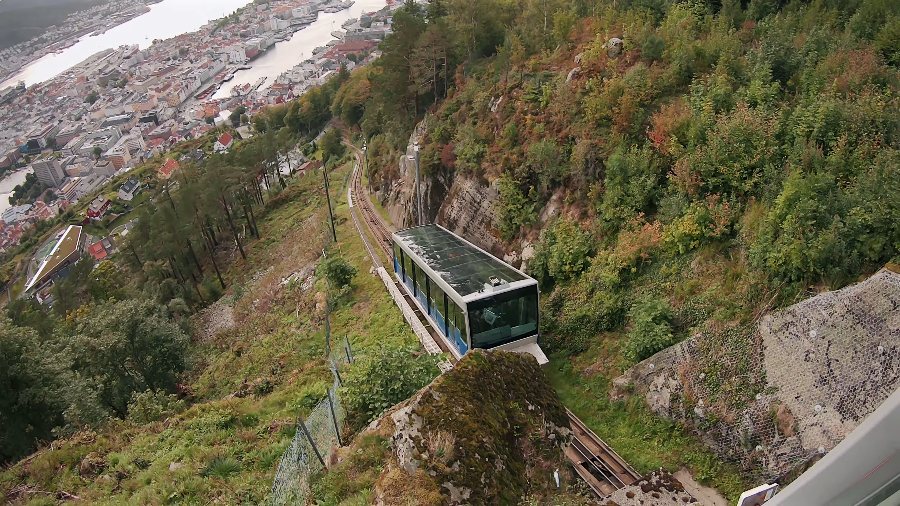 The Fløibanen funicular car on its track through the trees above the city