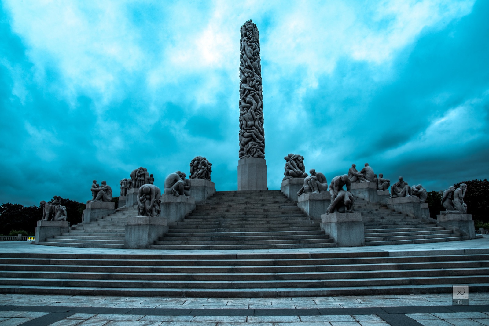 The granite monolith at the top of Vigeland Park under a stormy blue sky