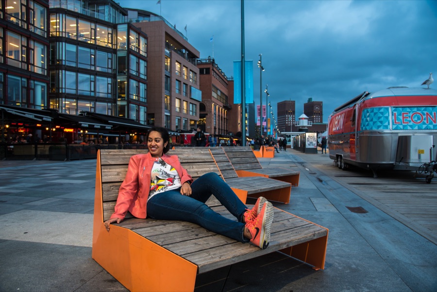 Meenu lounging on an orange bench by the marina at Aker Brygge