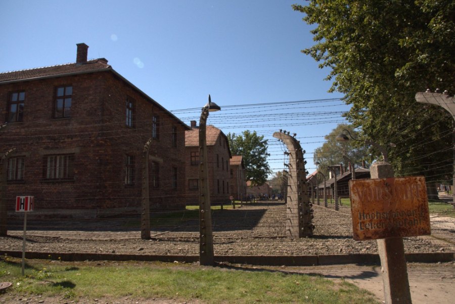 Brick blocks behind rows of barbed wire on concrete posts at Auschwitz