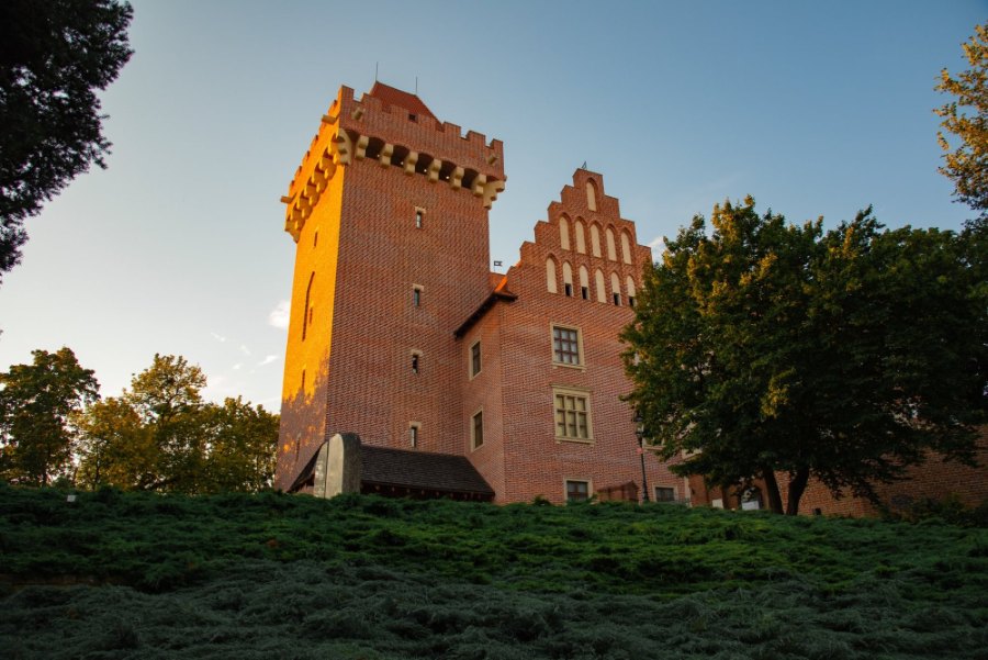The brick tower and stepped gable of Poznań's Royal Castle in the last of the evening sun