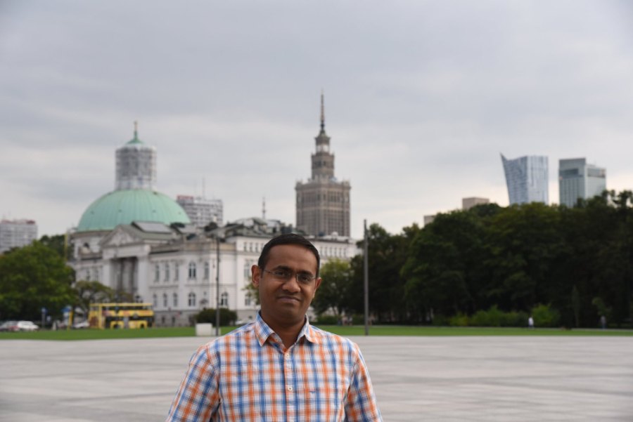 Praddy on Piłsudski Square, with a green-domed church and the Palace of Culture and Science behind him