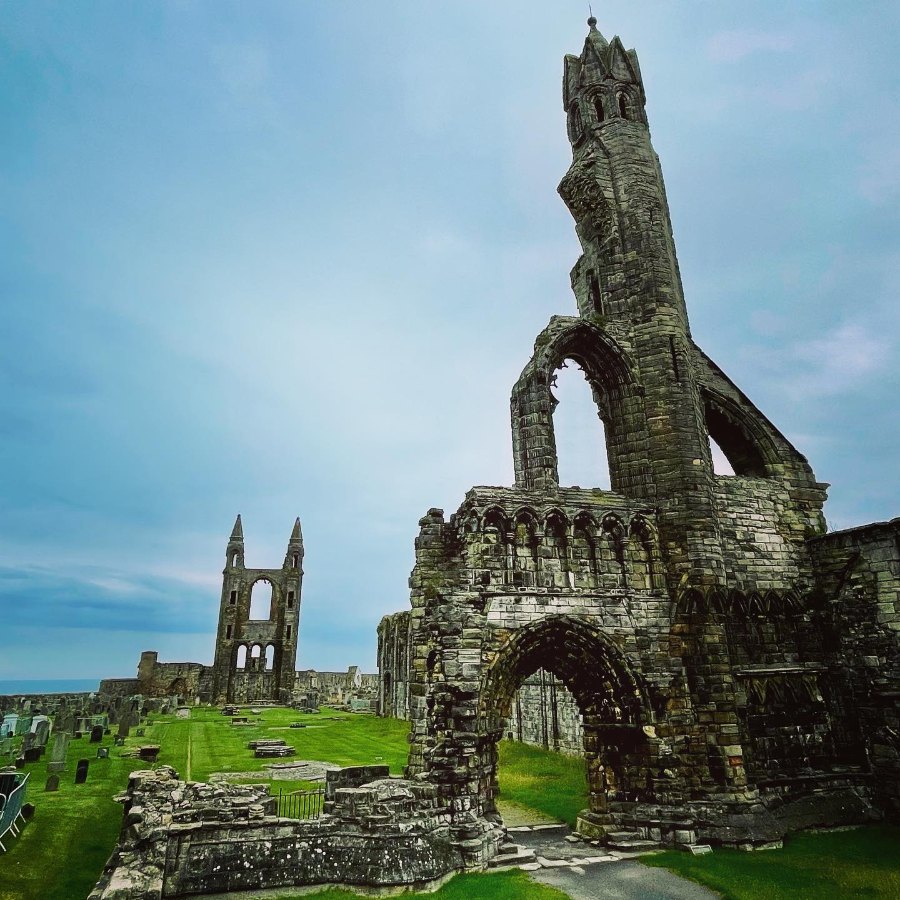 The broken arches of St Andrews Cathedral, with two tall spires still standing behind