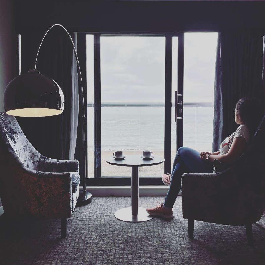 Meenu in an armchair at the window of our room at Number 44, looking out to sea