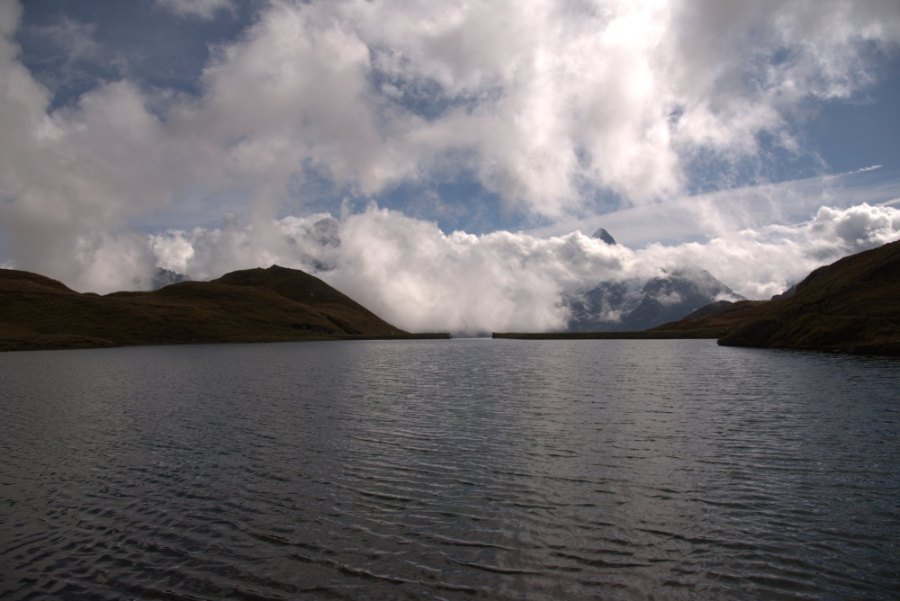 The Bachalpsee under a bank of cloud, between grassy ridges