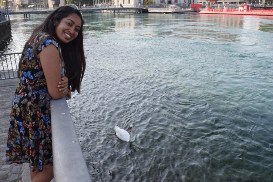Meenu leaning on the rail above the clear water of the Rhône, with a swan below