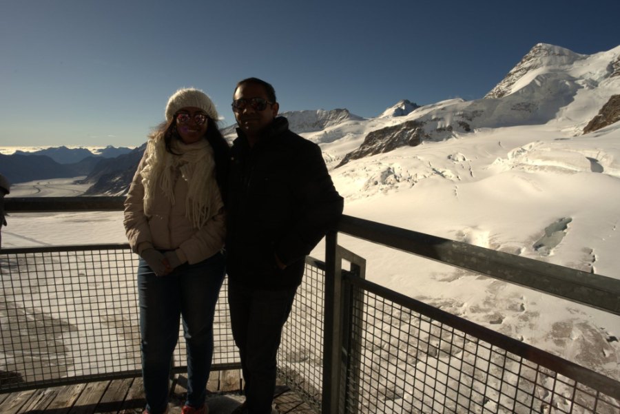The two of us wrapped up warm at the terrace railing, with the glacier behind