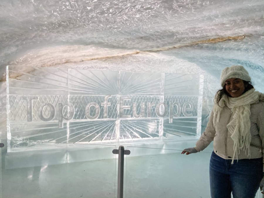 Meenu in a woolly hat beside the Top of Europe ice carving in the Ice Palace