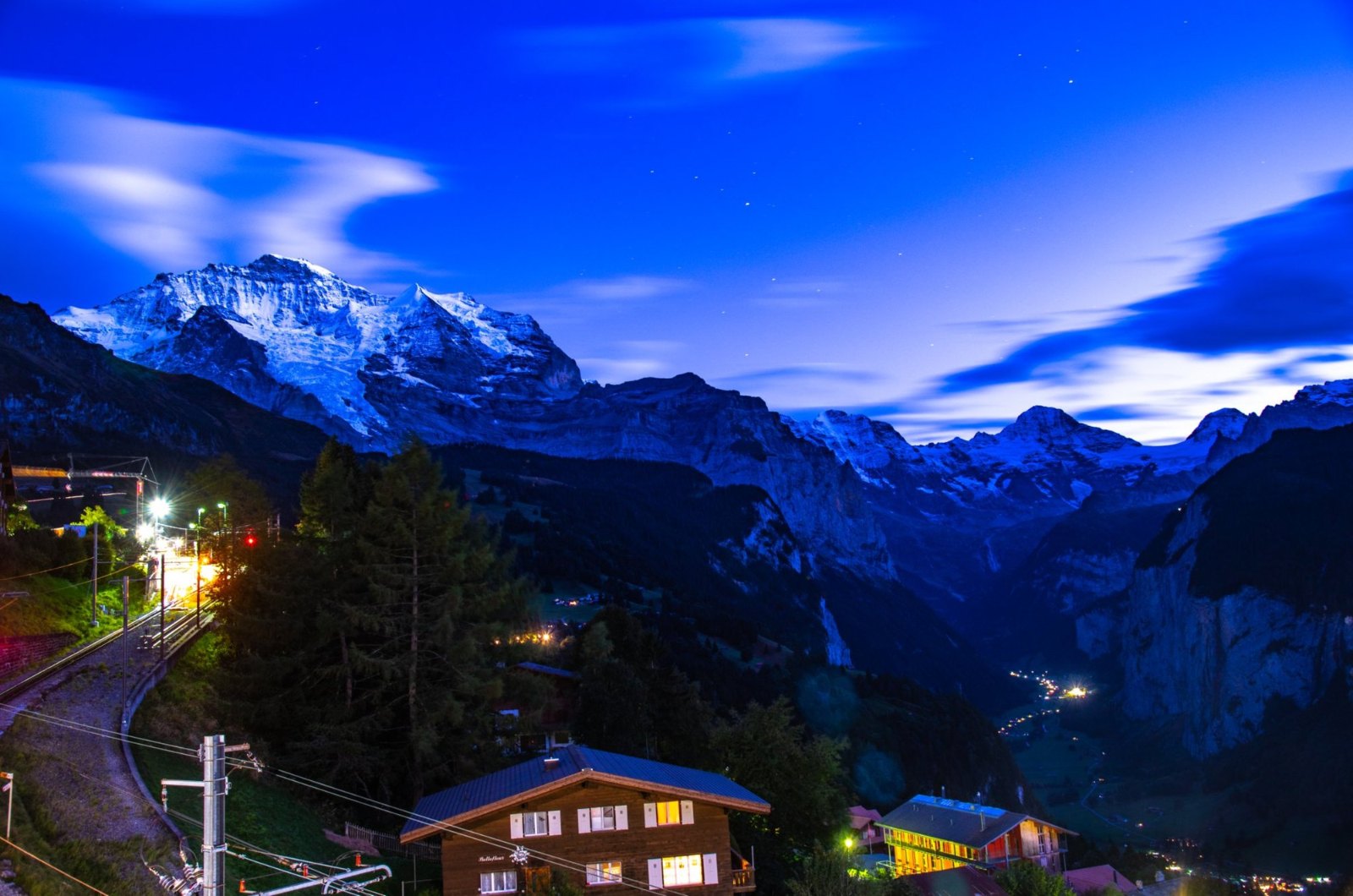 The Jungfrau glowing white above Wengen's lights at blue hour