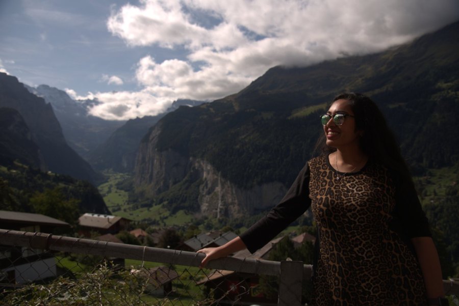 Meenu at a wooden railing above the Lauterbrunnen valley and its sheer grey cliffs