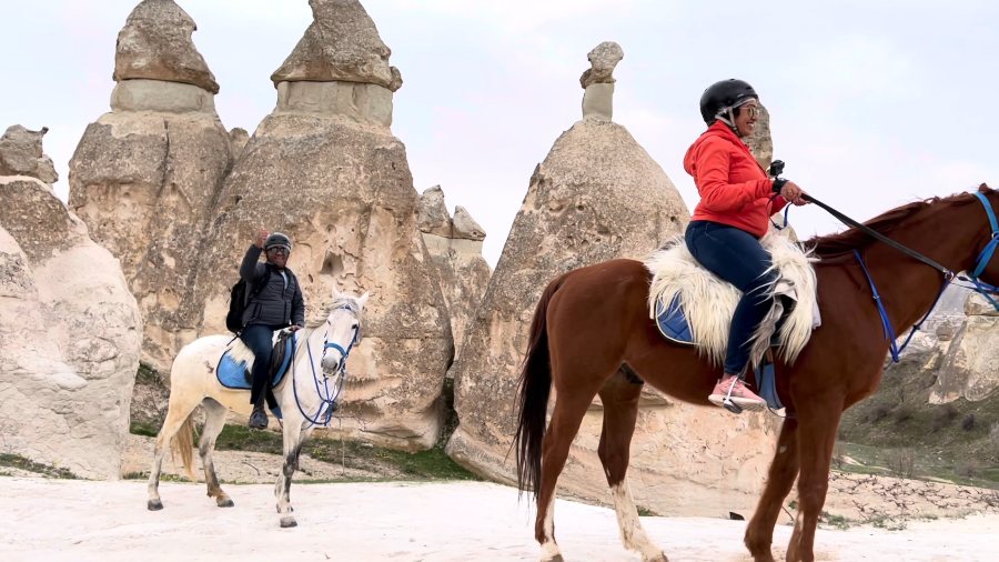Riding horses among Cappadocia's fairy chimneys